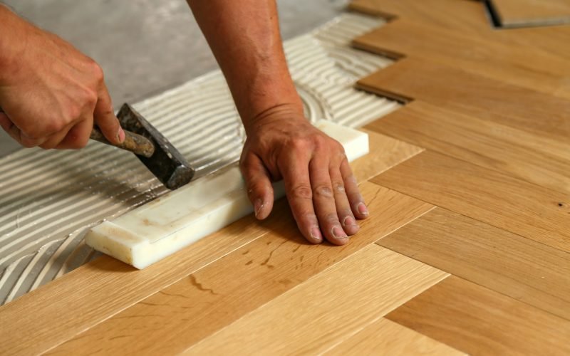 Worker installing parquet flooring